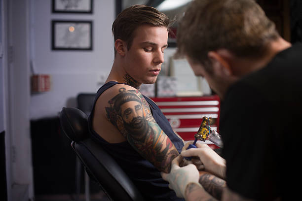 istock Artist tattooing man's hand 492261662