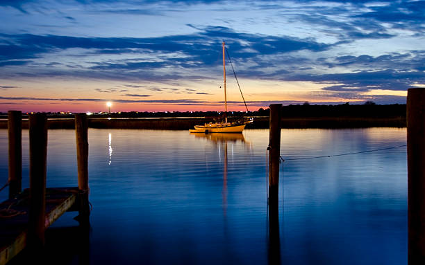 Sailboat in Shimmering Water at Dusk stock photo