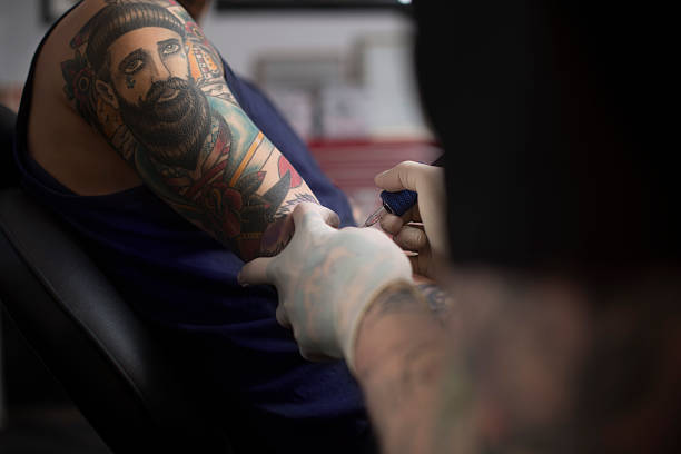 istock Artist tattooing man's hand 492261770