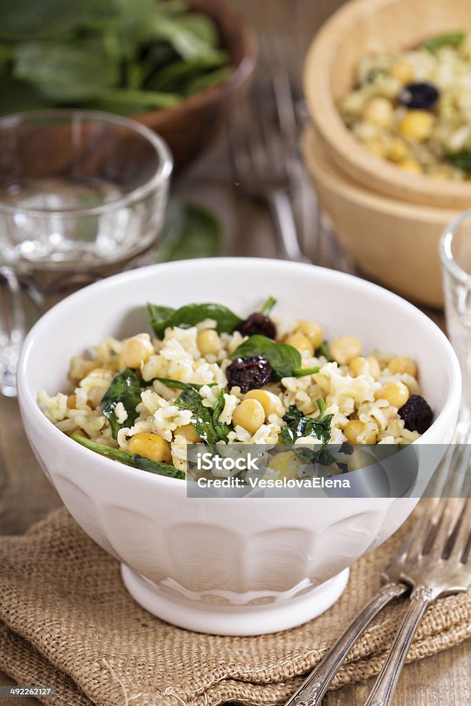 Salad with rice, chickpeas, spinach, raisins Warm salad with brown rice, chickpeas, spinach, raisins Appetizer Stock Photo