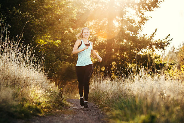 Cute girl, jogging in the park, wearing headphones, listening music