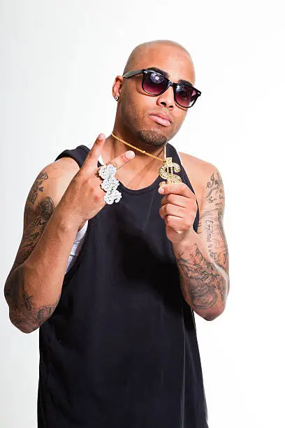 Hip hop urban gangster black man wearing dark shirt and bling bling isolated on white. Looking confident. Cool guy. Studio shot.