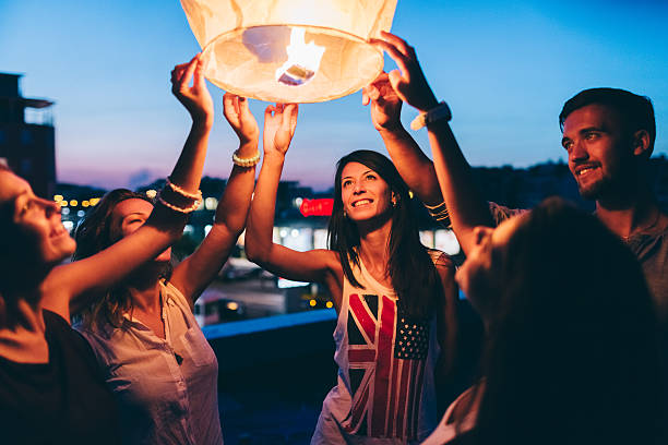 istock Friends on the rooftop releasing paper lantern 492273980