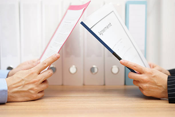 businessman and woman are reading agreement businessman and woman are reading agreement read the fine print stock pictures, royalty-free photos & images