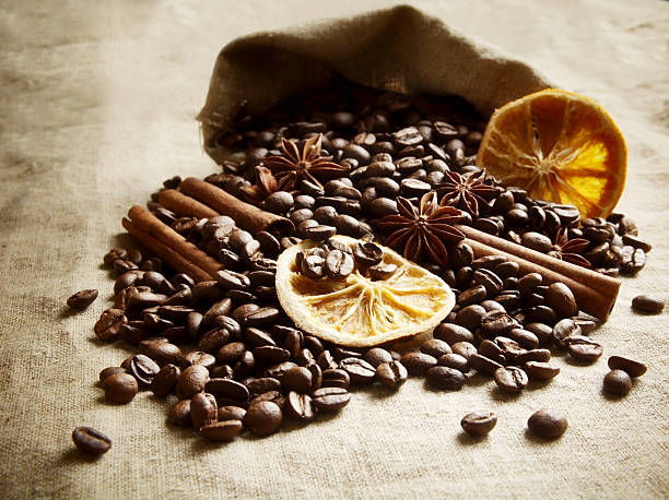 istock Overturned bag full of coffee beans,dried oranges on black 492275112
