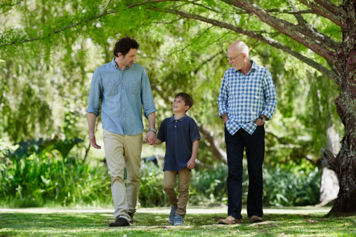 Full length of three generation males walking together in park