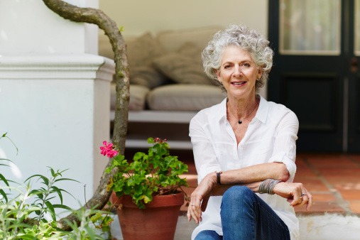 Portrait of confident senior woman sitting at porch