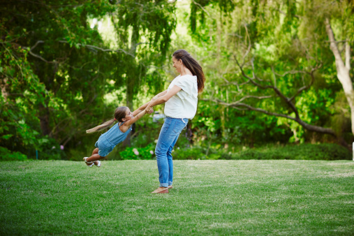 Full length of happy mother and daughter playing in park