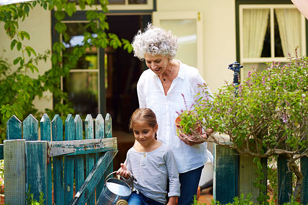 family with gardening equipment in yard - grandmother generation gap senior adult granddaughter fotografías e imágenes de stock