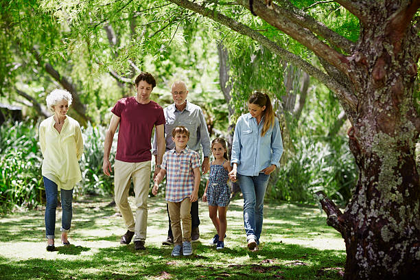 family walking together in park - family walking child park zdjęcia i obrazy z banku zdjęć