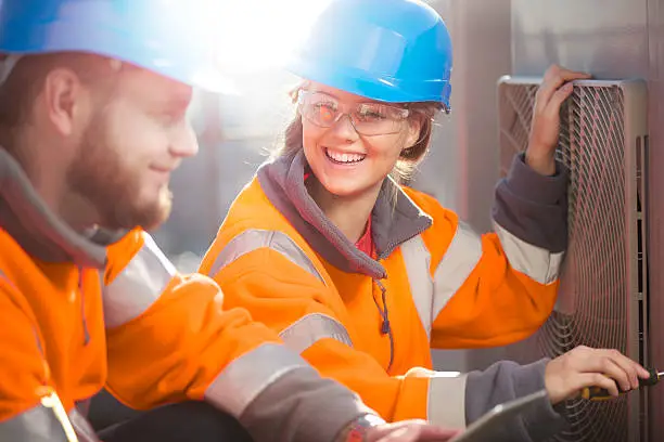 Photo of female air conditioning technician with her supervisor