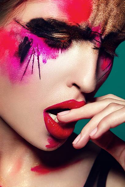 istock Beautifulgirl with creative colorful makeup on a green 492279690