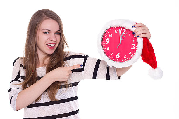 istock young woman in santa hat with clock posing isolated 492282316