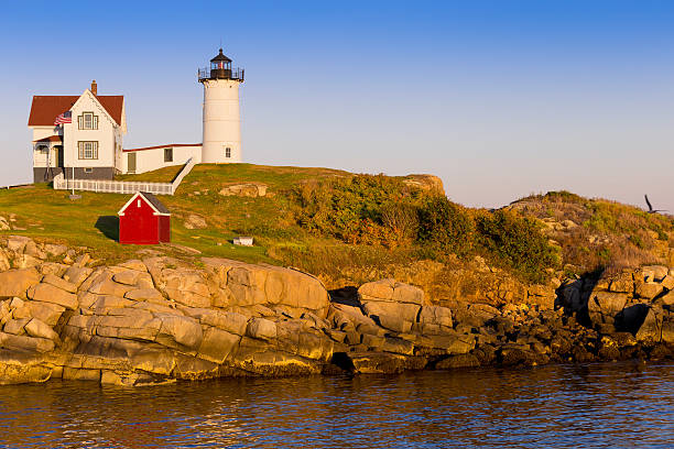 cape neddick (leuchtturm nubble) leuchtturm bei sonnenuntergang, york, maine, usa. - maine flag nubble lighthouse new england stock-fotos und bilder