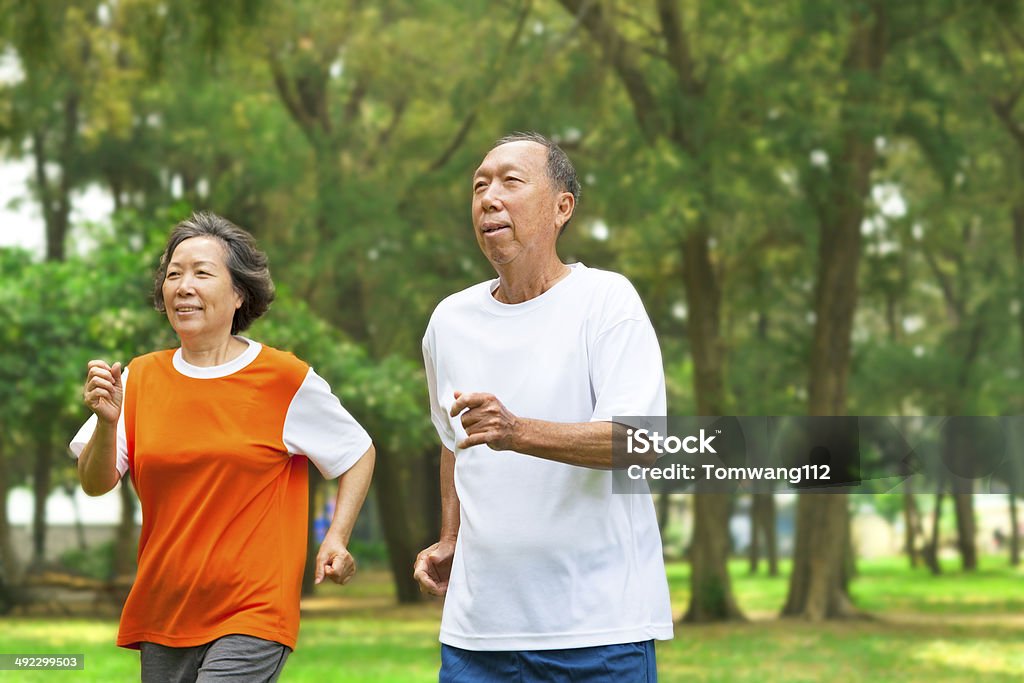 happy senior couple running together happy senior couple running together in the park China - East Asia Stock Photo