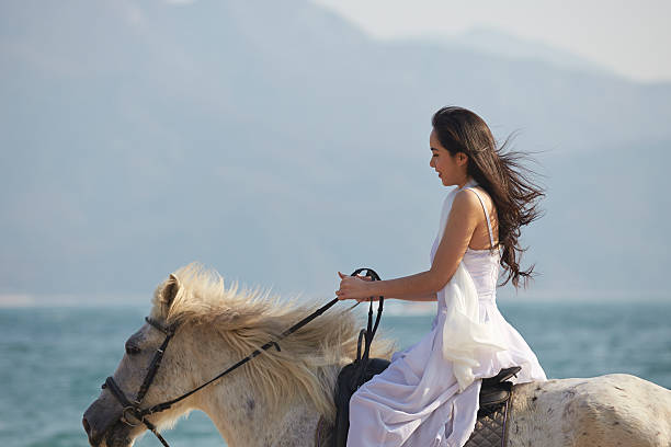 a Chinese woman riding horse on beach