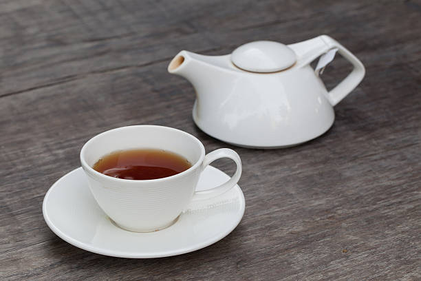 istock Cup of tea and tea's jar on old wooden 492304011