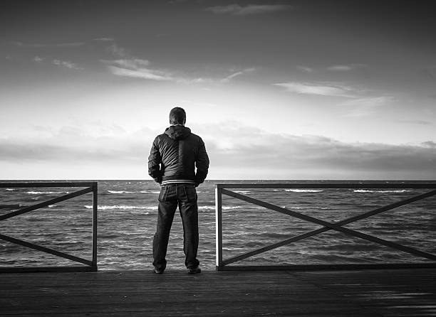 istock Young man looking on sea from wooden pier 492311208