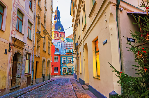Narrow street que conduce a la Iglesia de San Pedro en la antigua ciudad de Riga photo