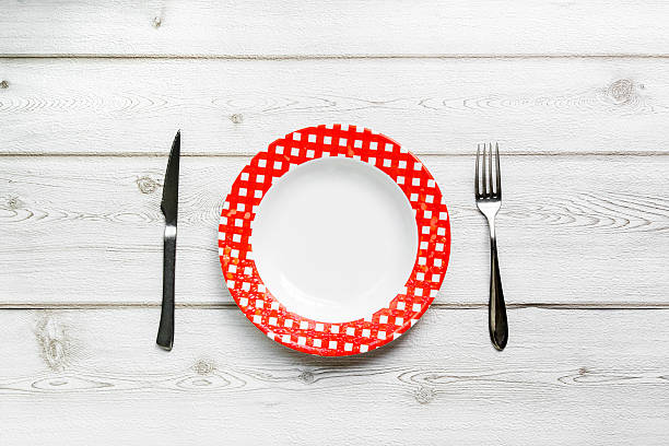 istock knife and fork and plate on wooden background 492311548