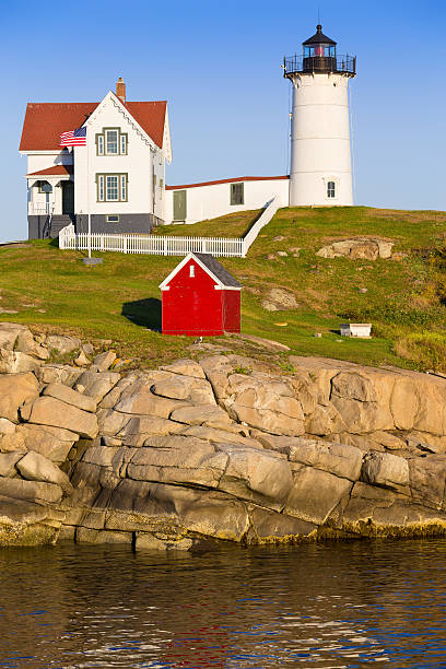 cape neddick (phare de nubble) au coucher du soleil, york, dans le maine, aux états-unis. - flag maine nubble lighthouse vertical photos et images de collection