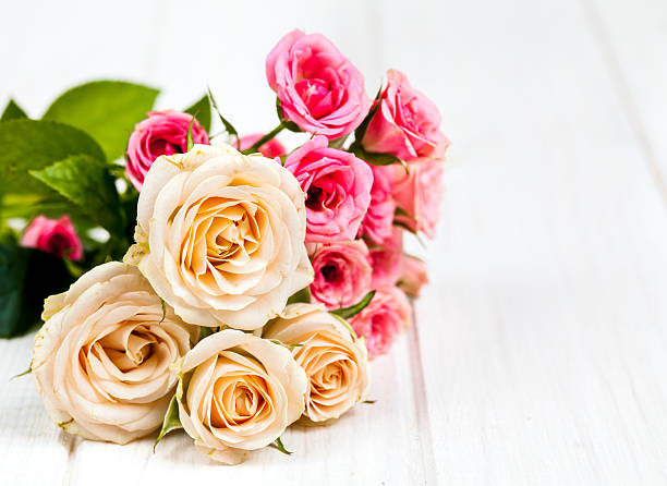 istock roses on white wooden planks background 492317938