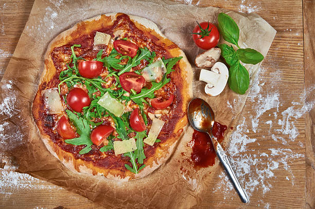 istock Delicious rustic homemade pizza with cherry tomatoes, cheese, and rucola 492318410
