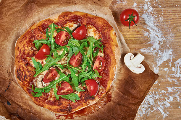 istock Delicious rustic homemade pizza with cherry tomatoes, cheese, and rucola 492318482