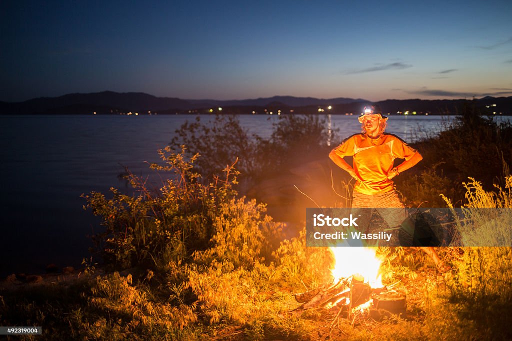 Hiking tourist have a rest in his camp at night Hiking tourist have a rest in his  camp at night near campfire 2015 Stock Photo