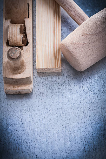 istock Wooden shaving plane hammer stud on metallic background construc 492319576