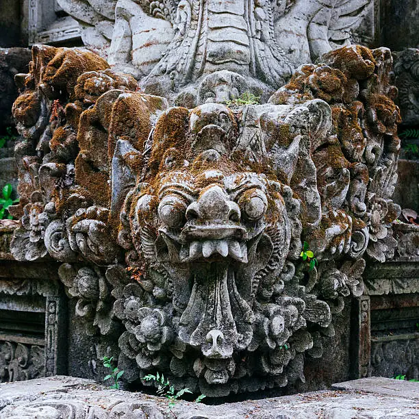 A Balinese Barong stone carving at the Pura Gunung Lebah Temple near the Campuhan Ridge in Ubud, Bali, Indonesia. Barong is a mythical lion like creature who is the king of the spirit world in Balinese Hinduism.