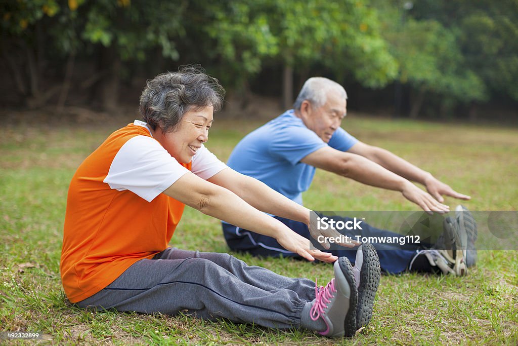 Happy elderly seniors couple working out in park Happy elderly seniors couple working out on a meadow in park Asia Stock Photo