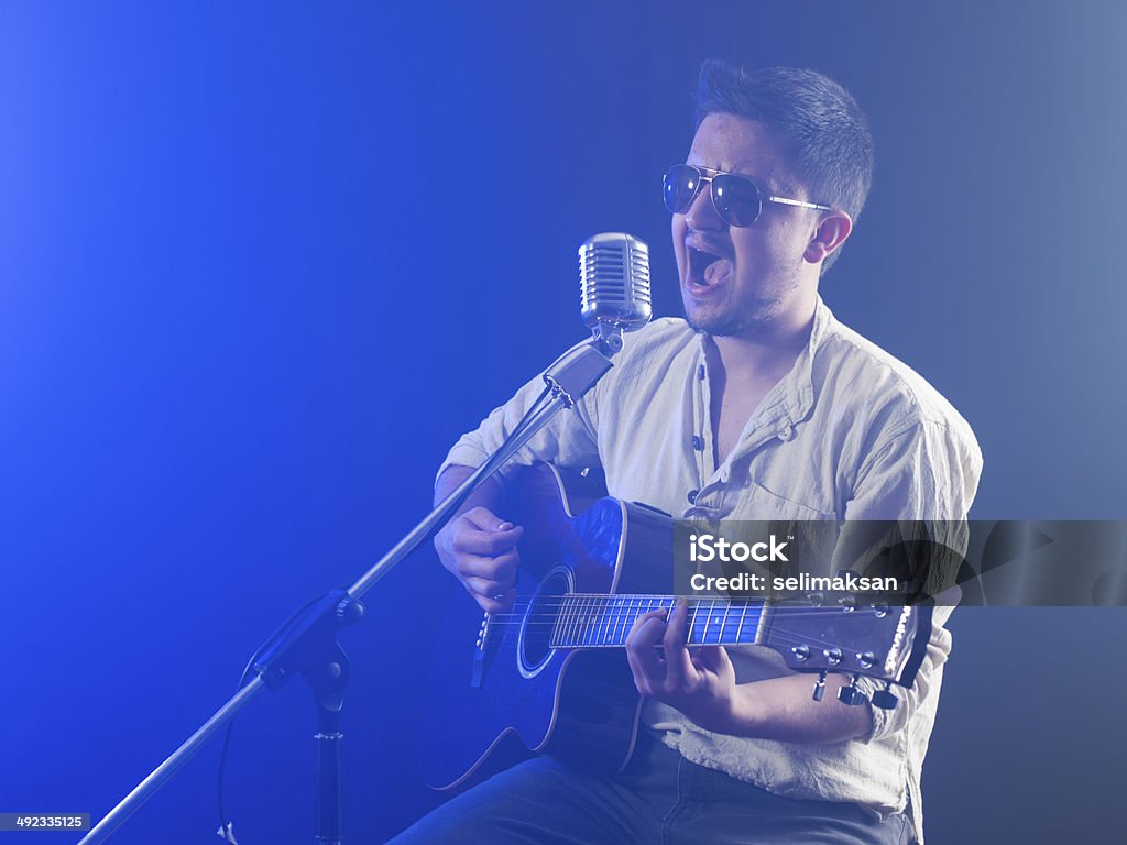 Ritratto di un giovane Musicista suona la chitarra acustica in fumo - Foto stock royalty-free di Abilità