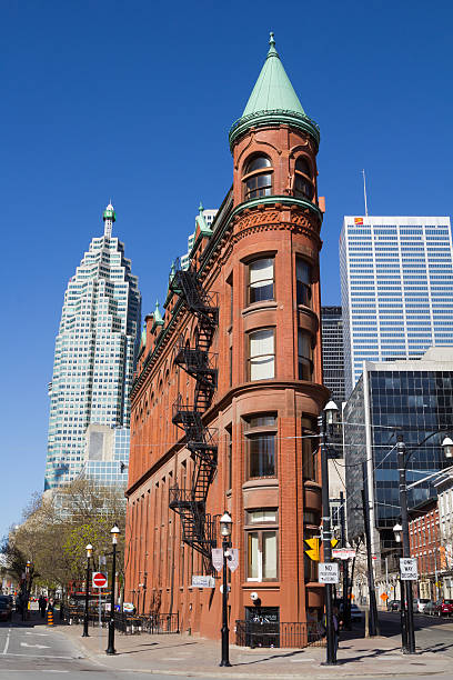 Flatiron (Gooderham)  Building in Toronto Toronto, Canada - 11th May 2014: The Flatiron (Gooderham) Building in Toronto during the day with Downtown skyscrapers in the background. People and vehicles can be seen in the street. flatiron building toronto stock pictures, royalty-free photos & images