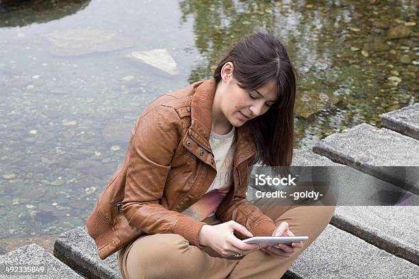 Use Of The Digital Tablet Near The Water Area Stock Photo - Download Image Now - Adolescence, Adult, Beauty In Nature