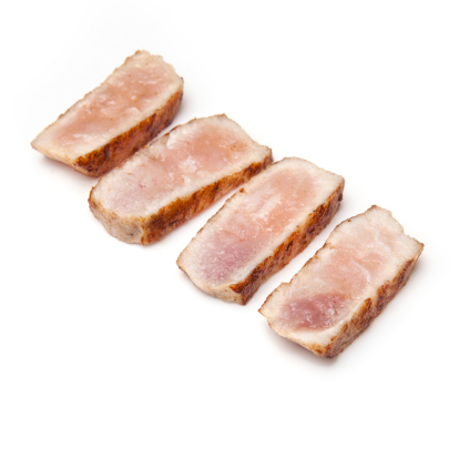 Cooked crocodile meat isolated on a white studio background.