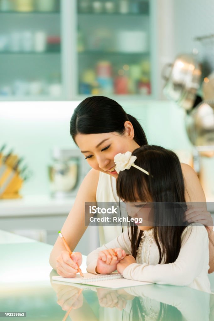 Chinese Schoolwork A Chinese woman and a girl work on schoolwork. 20-29 Years Stock Photo