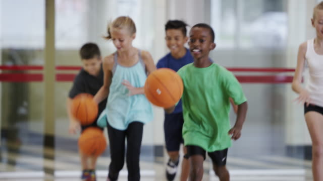 Elementary kids playing basketball during physical education class