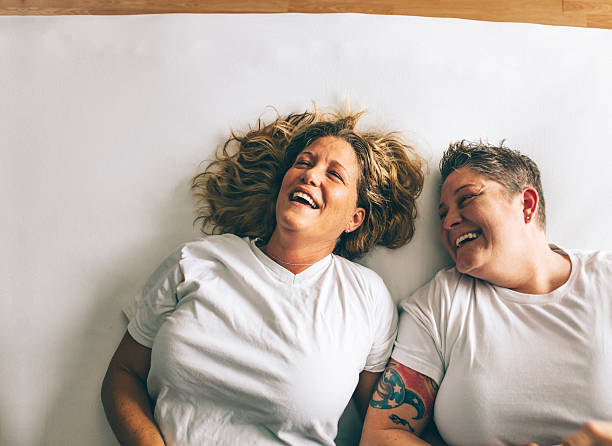 female couple laughing together stock photo