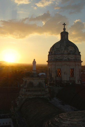The tower of La Merced Church in Granada, Nicaragua is silhouetted against the setting sun.