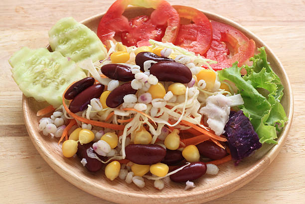 istock Healthy salad with fresh vegetables on wood background 492361540