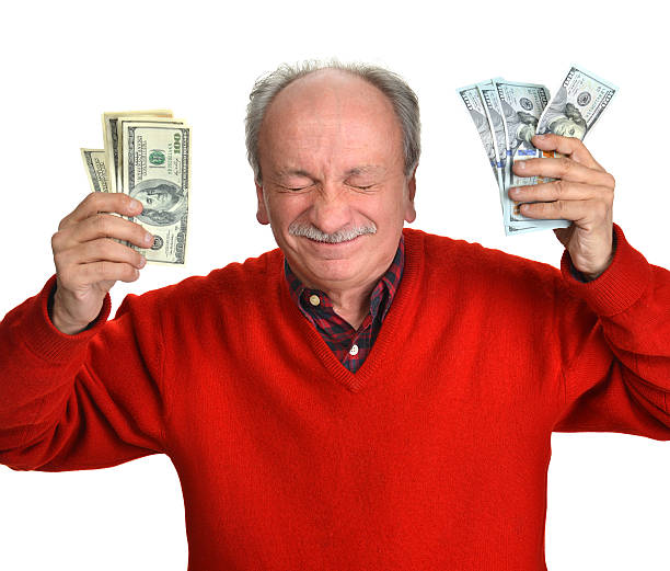 istock Lucky old man holding dollar bills 492362523
