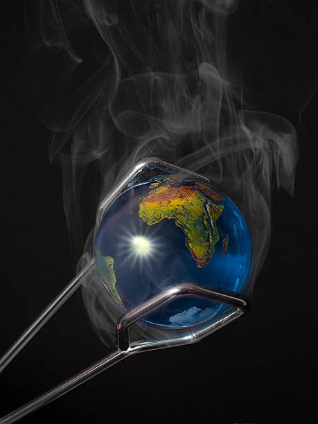 istock Steaming Planet Earth Held by Tongs Illustrating Global Warming. 492362672