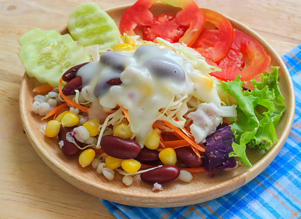istock Healthy salad with fresh vegetables on wood background 492363480
