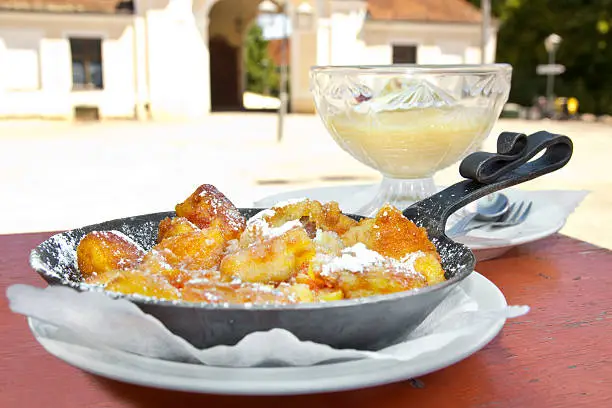 Austrian and bavarian dessert speciality "Kaiserschmarrn" with apple juice in the original environment of a castle courtyard