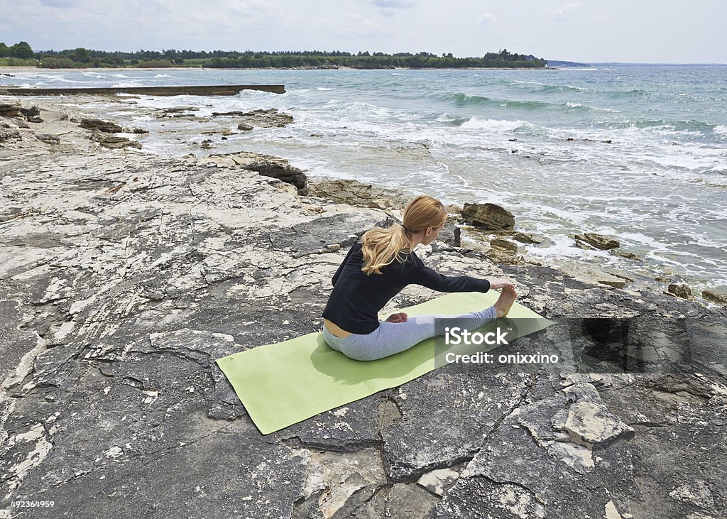 Healthy woman resting and curl up in fetal position outdoor Healthy woman resting and curl up in fetal position outdoor at the sea: yoga pose. Series. Adult Stock Photo