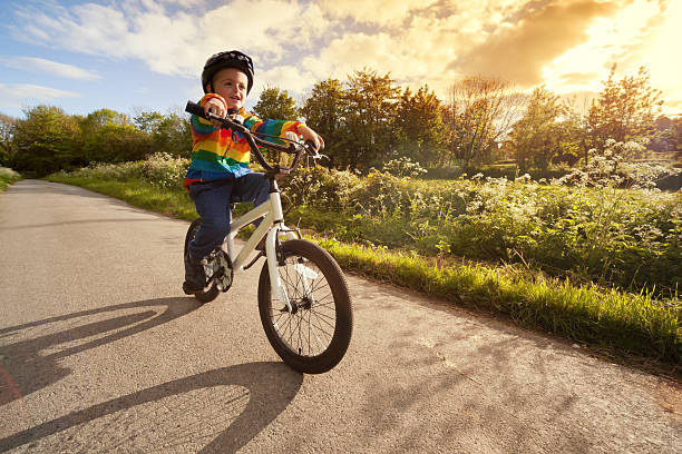 child on a bicycle at asphalt road in early morning. Boy on bike in the city