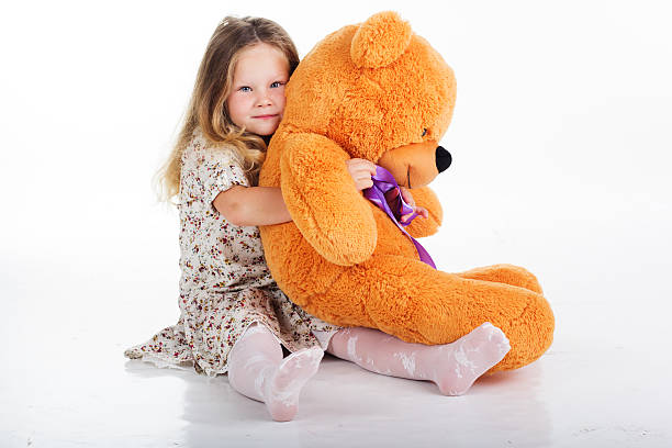 istock Child girl is holding her teddy bear 492370556
