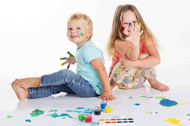 istock Two childs are drawing by aquarelle paints on white paper 492371016