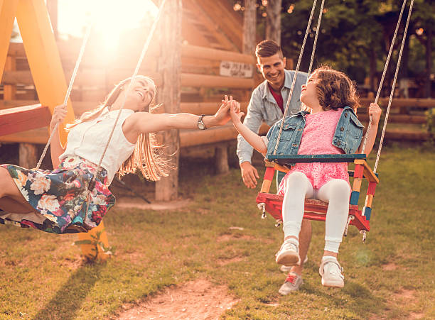 istock Mother and daughter swinging and holding hands. 492371958